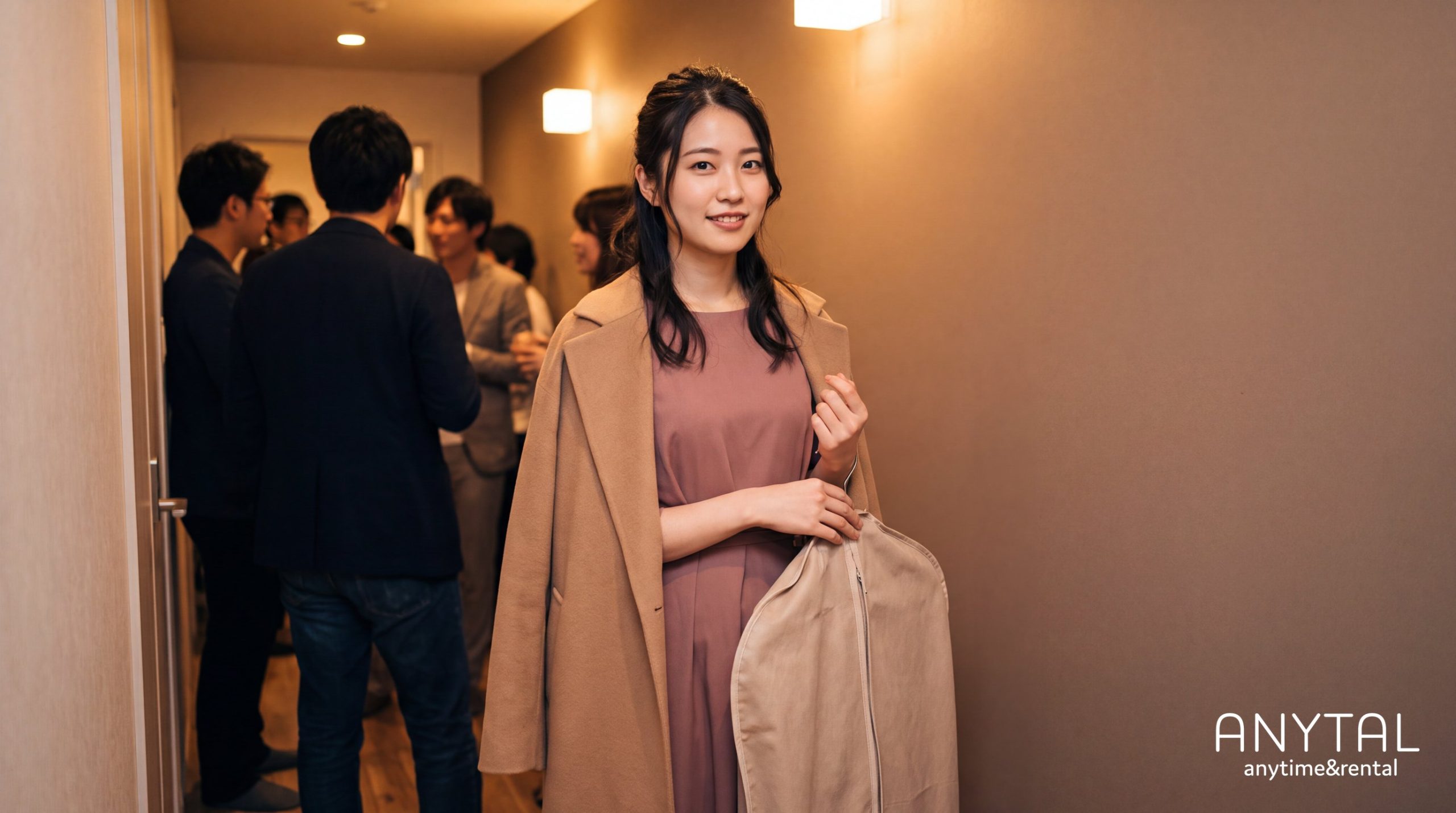 同窓会の会場で、くすみピンクのドレスにベージュのジャケットを合わせ、衣装を入れた袋を持つ女性