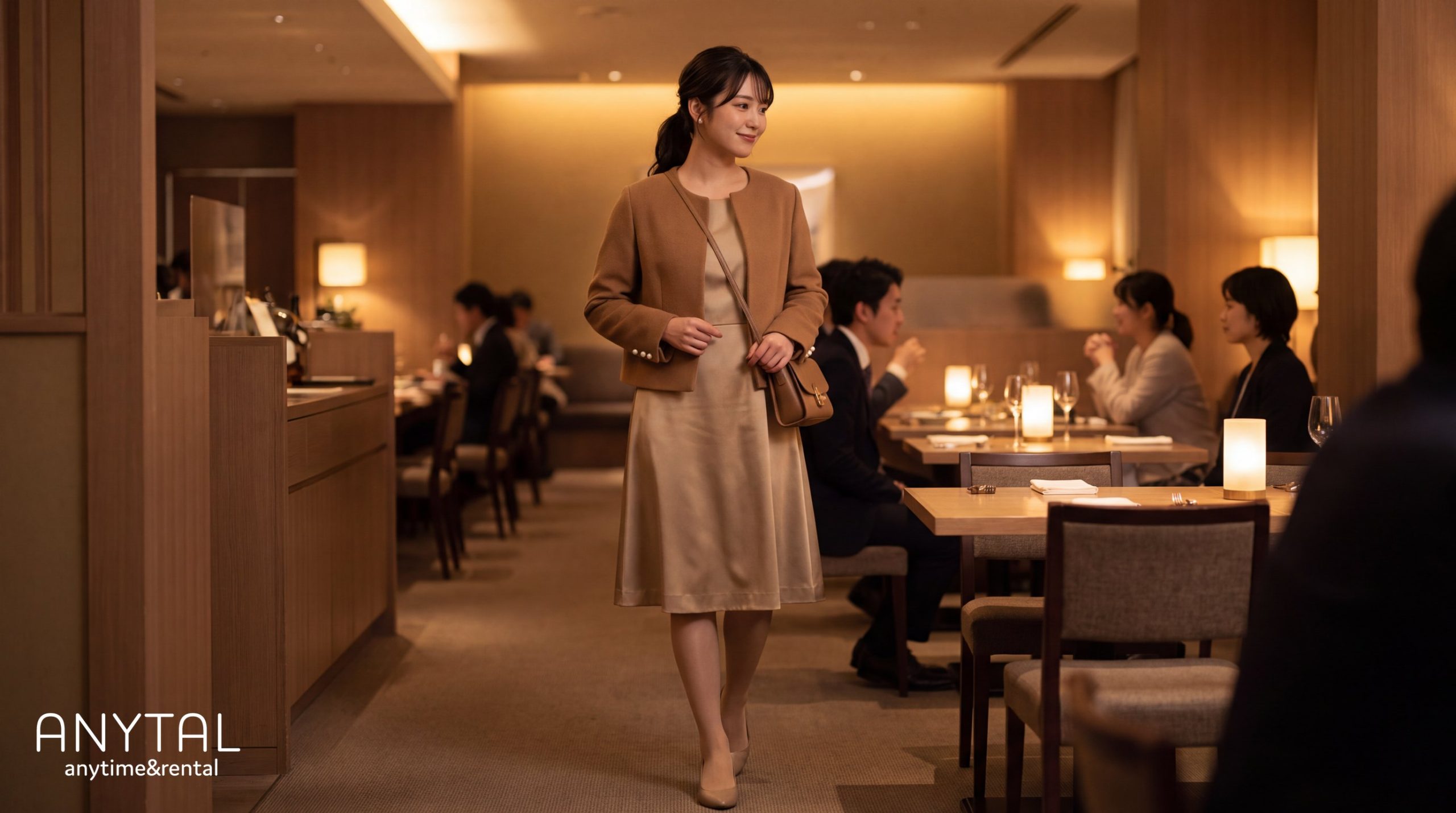 ベージュのワンピースとブラウンのジャケットを合わせ、レストランでスマートカジュアルの装いをする女性